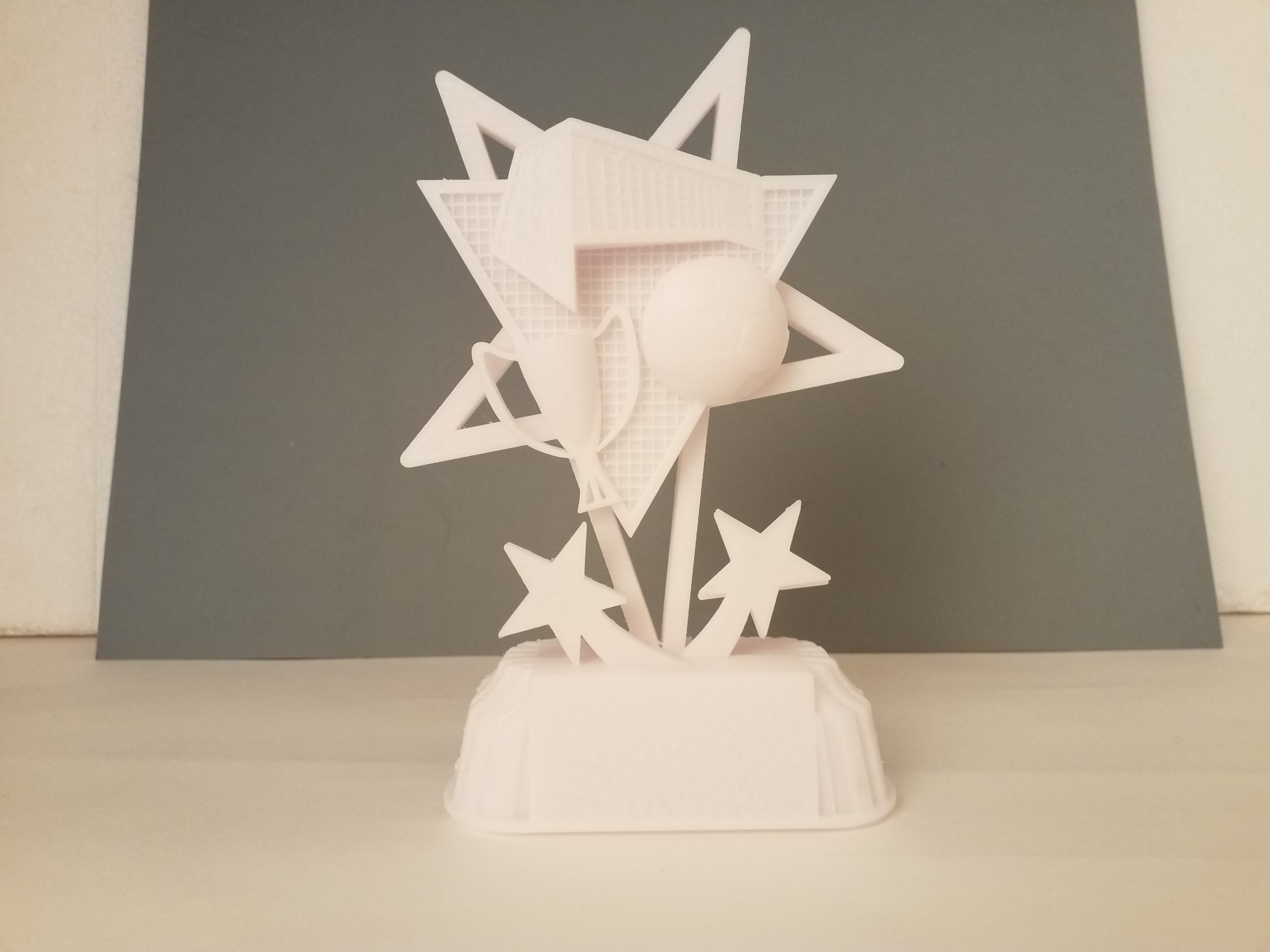 Maquette blanche de trophée, composée de formes géométriques sur un socle.